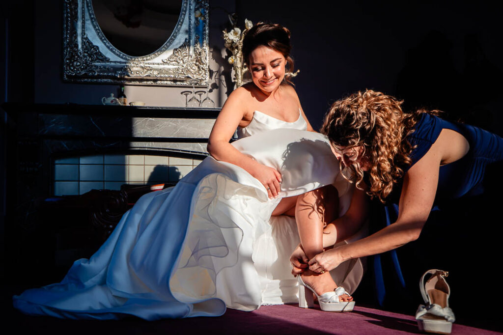 bruid trekt haar schoenen aan bij de bruiloft in rotterdam